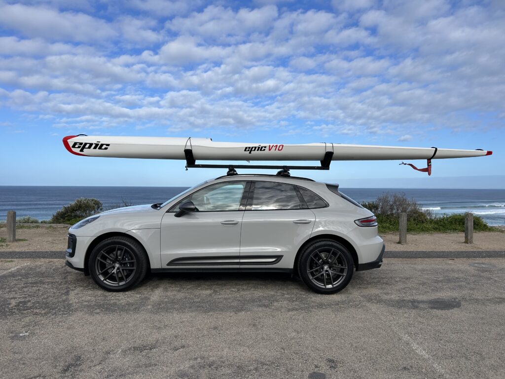 Car with Vrack installed on roof rack carrying kayak v10 parked near beach